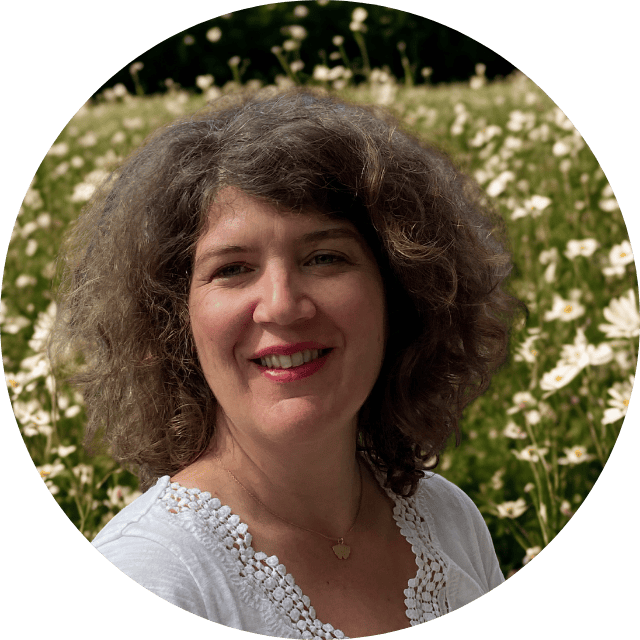 Femme souriante dans une champ de fleur. Caroline Henry Coach de vie, psy & bilan de compétences à Aix-en-Provence ou en ligne