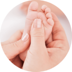 mère qui masse le pied de son bébé pour apprendre le massage bébé